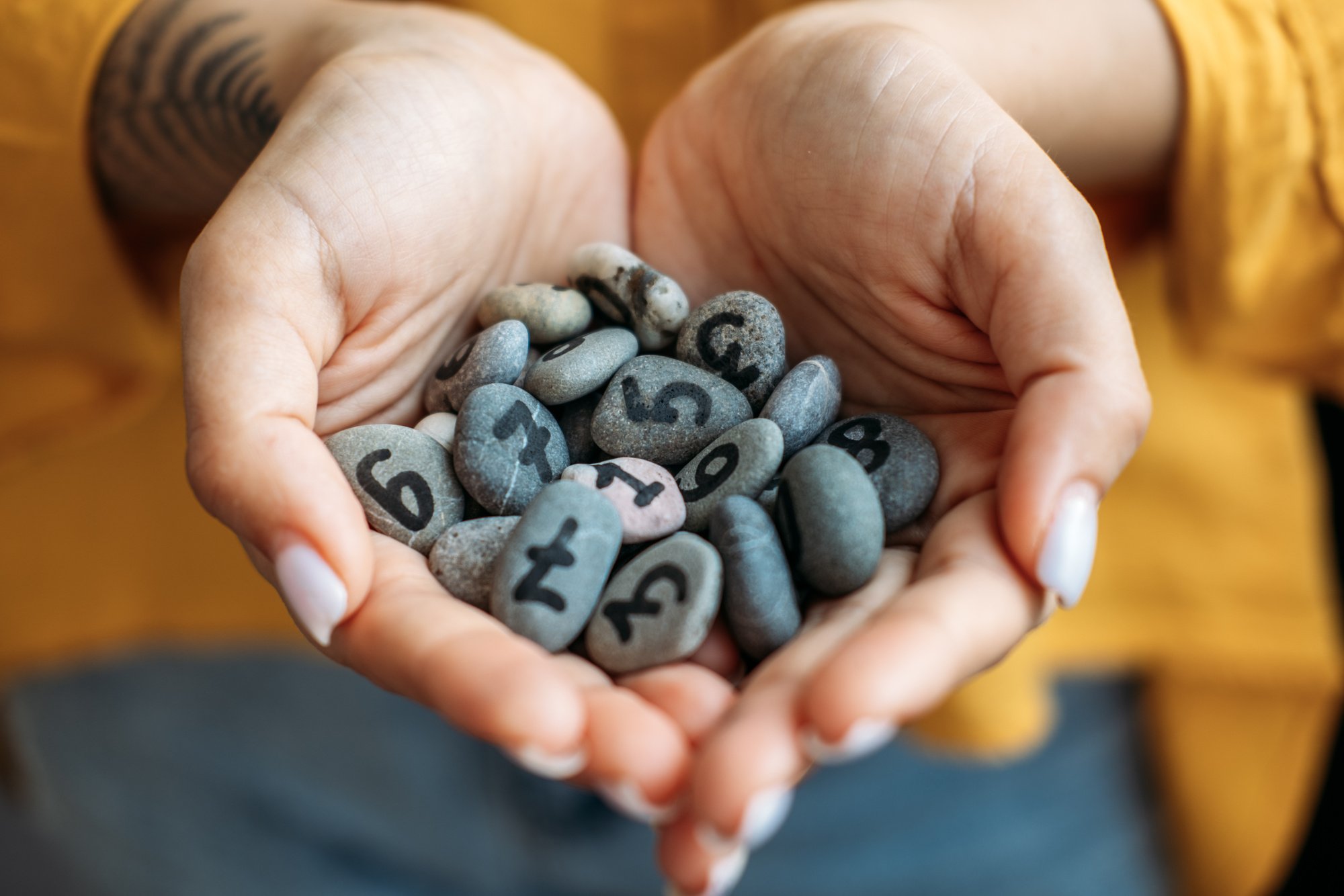 Woman Holding Pebbles With Numbers 